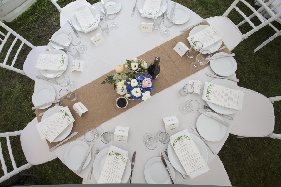 Round wedding table with crockery, glassware and flowers, photographed by Tandem Photography
